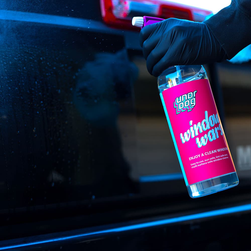 Window Warsh bottle beside a vehicle window