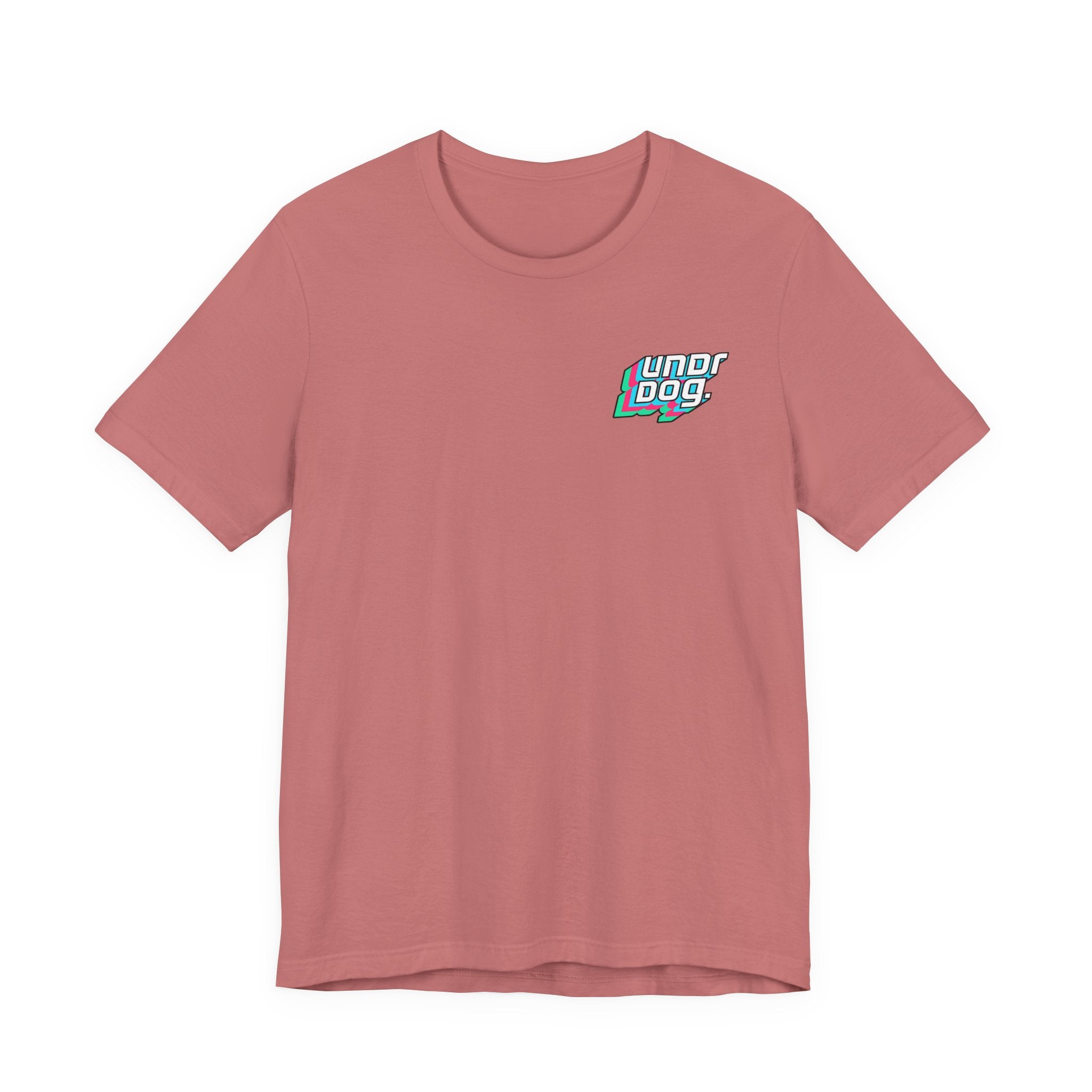 A light red Printify Unisex Jersey Short Sleeve Tee, featuring a small, colorful "Underdog" logo on the left chest. Made from soft Airlume combed cotton, this shirt is displayed laid flat on a plain white background.