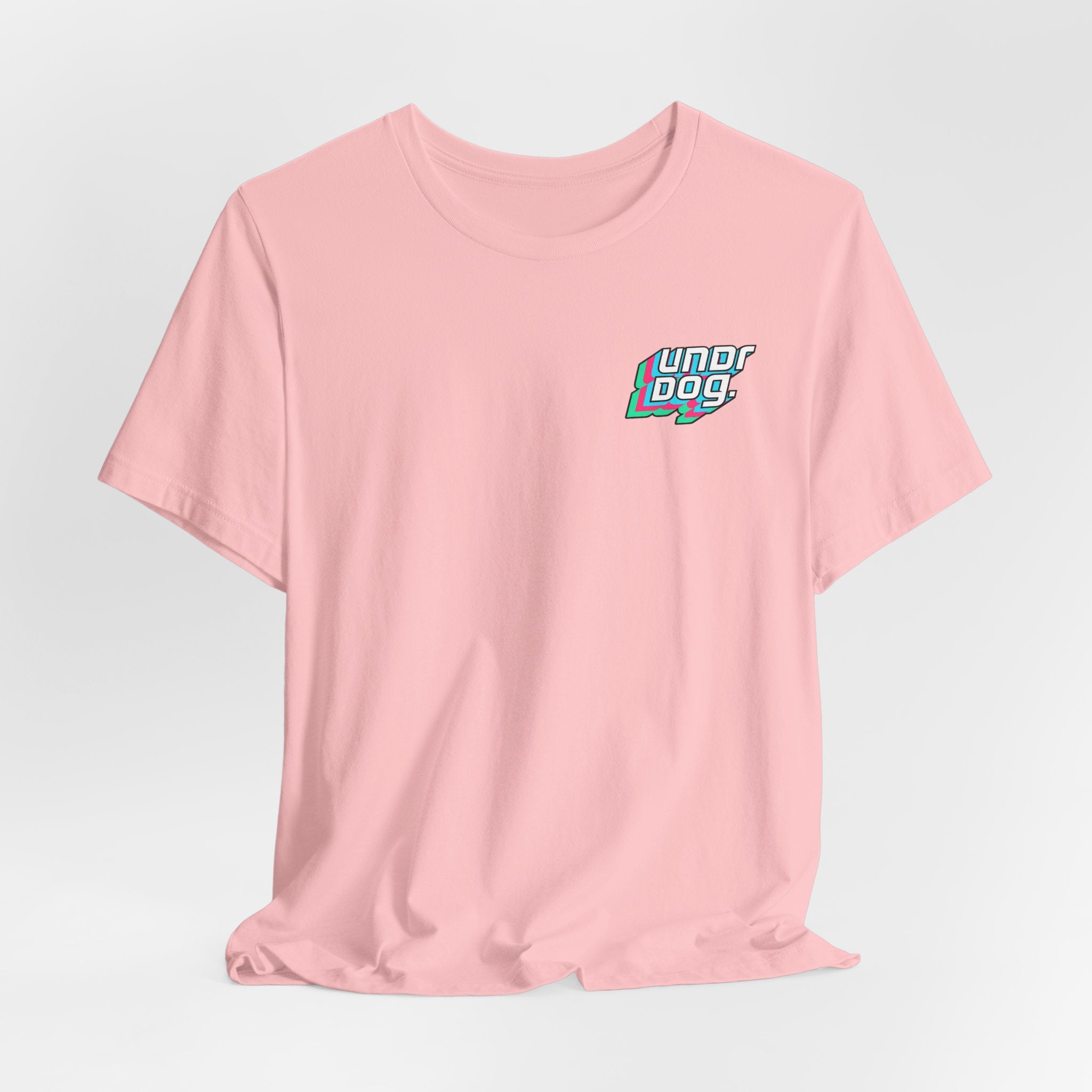 A light pink Unisex Jersey Short Sleeve Tee by Printify, made from soft Airlume combed cotton, features a small, colorful "Underdog" graphic on the left chest. Inspired by the popular Bella Canvas 3001 fit for ultimate comfort and style, this t-shirt is displayed against a plain white background.