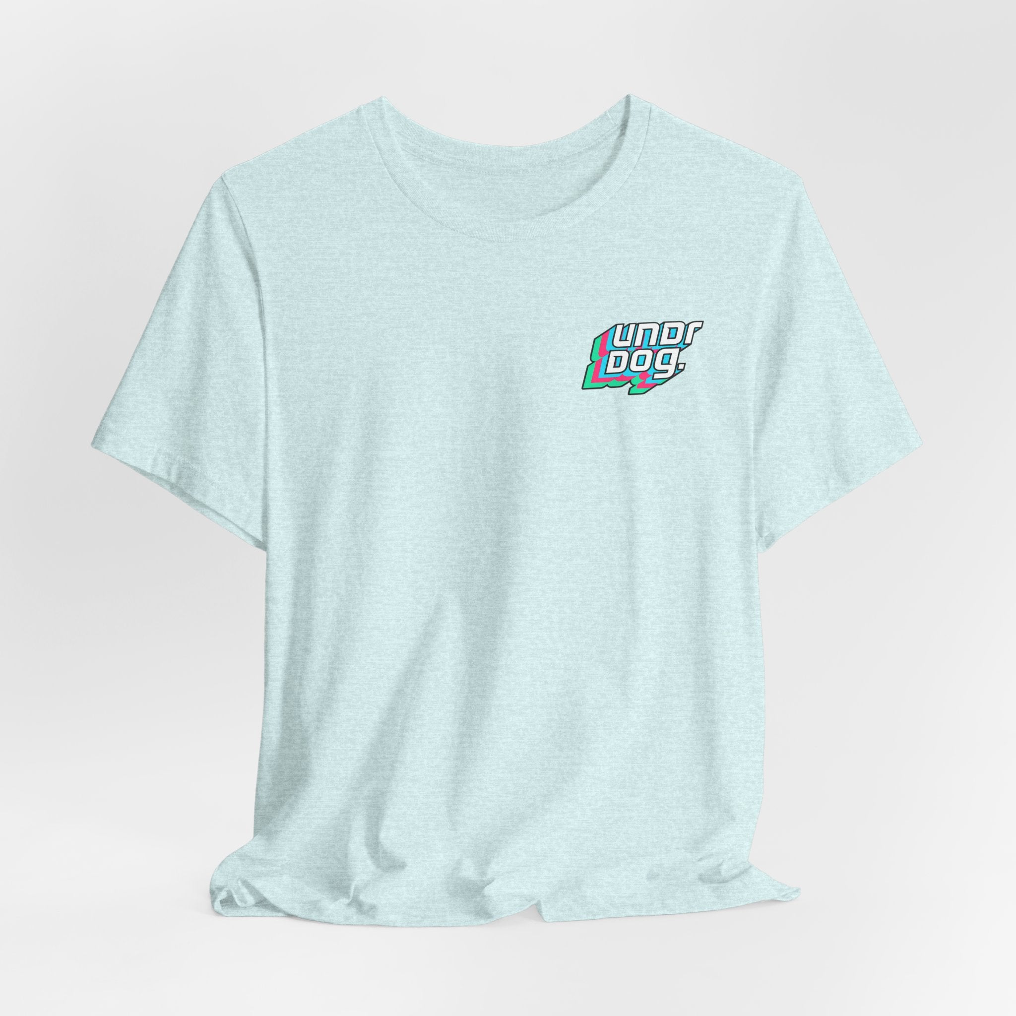 Light blue Unisex Jersey Short Sleeve Tee by Printify, crafted from premium Airlume cotton and featuring a small, colorful "Underdog" graphic on the left chest. This shirt is shown against a plain white background.