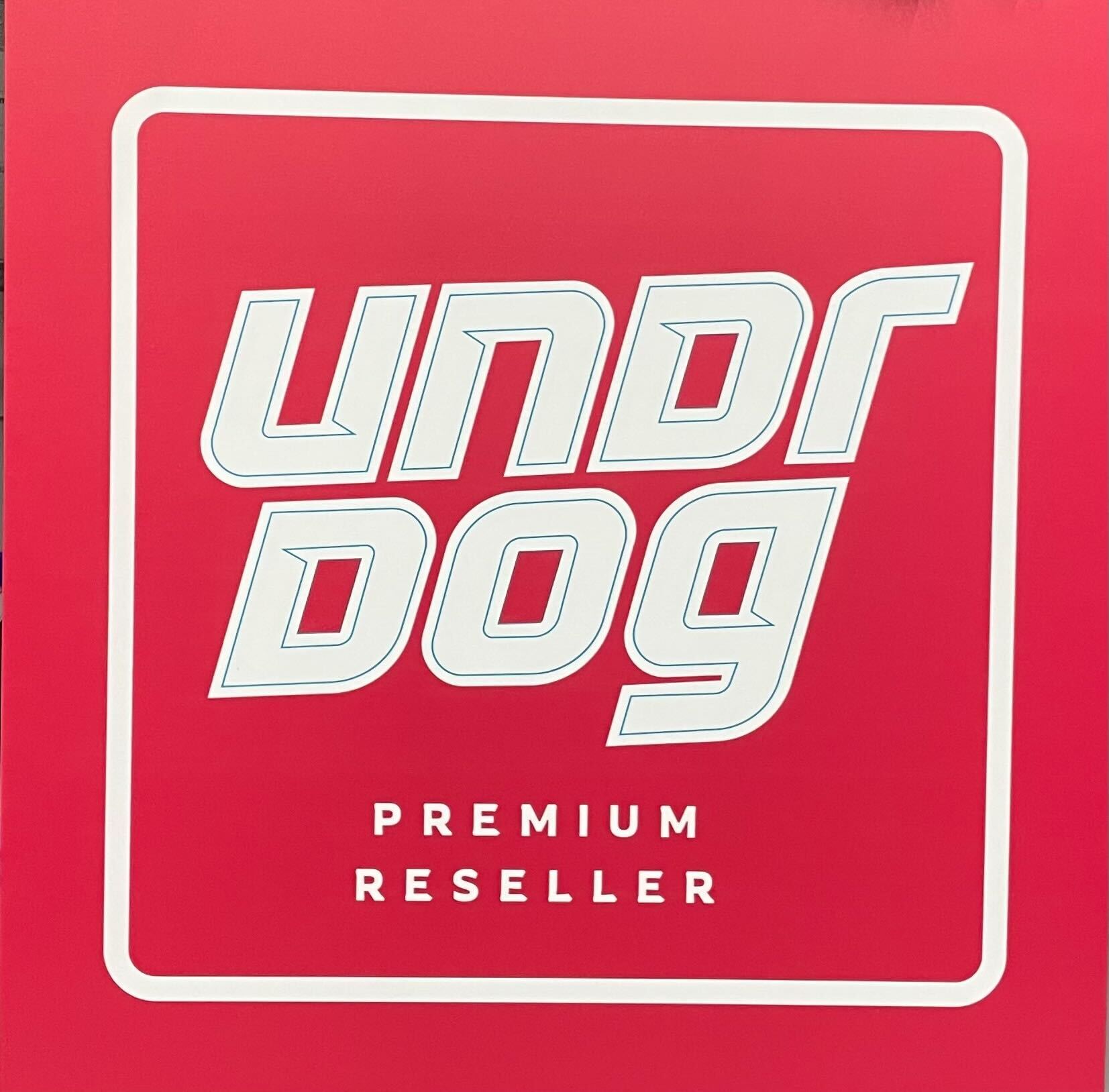 The Undrdog Authorized Reseller Sign by Undrdog Surface Products features a red background with bold, stylized white text reading "UNDR DOG" and smaller text below stating "Authorized Premium Reseller.