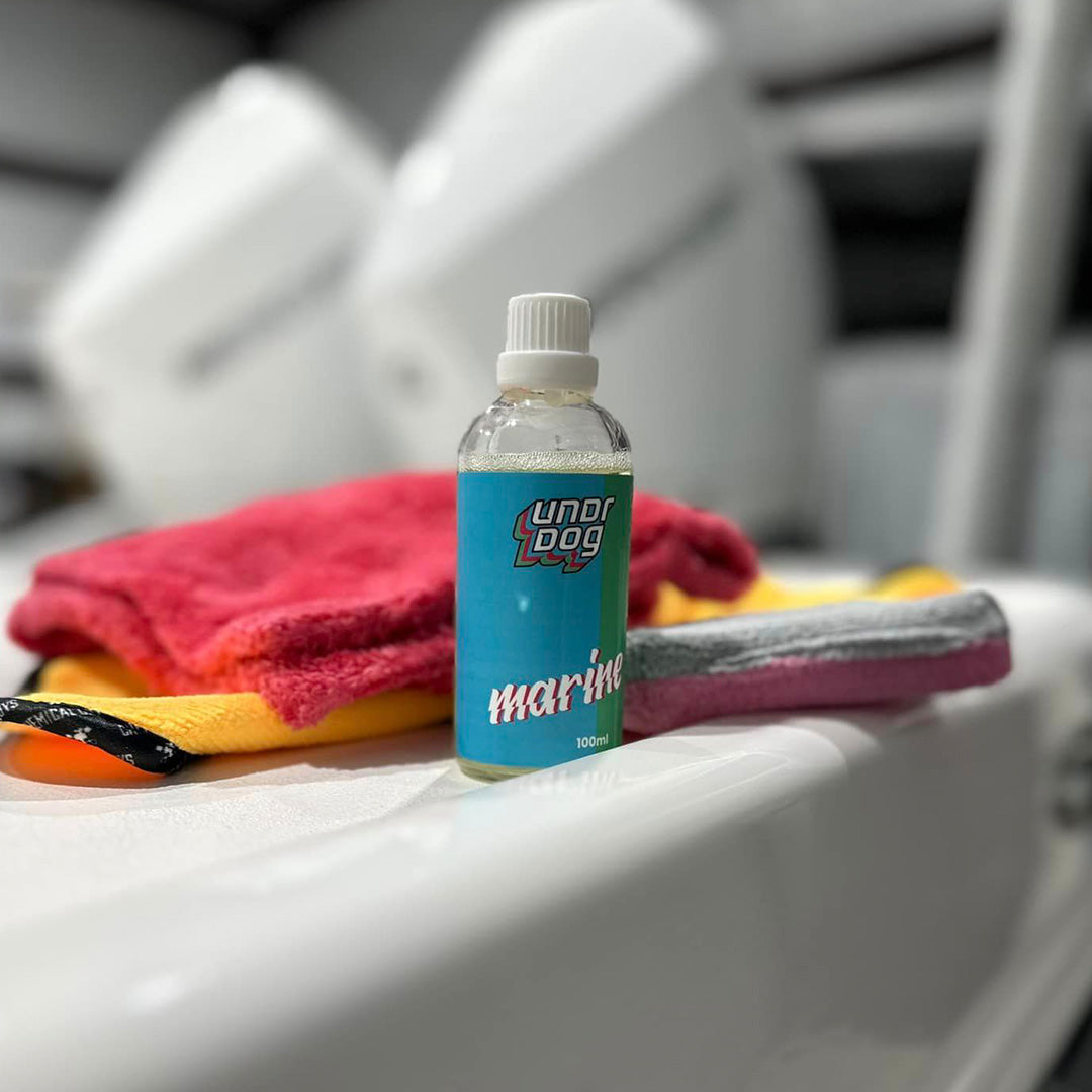Undrdog Marine bottle, cloths, and applicator aboard a boat as general marine-care context