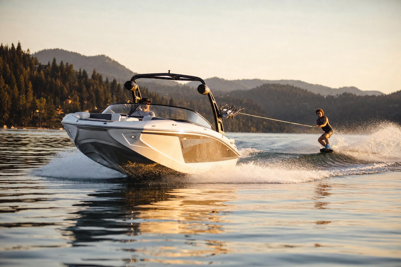 Wakeboard boat with tower carving a glassy lake at golden hour, freshly protected ceramic-coated gelcoat hull