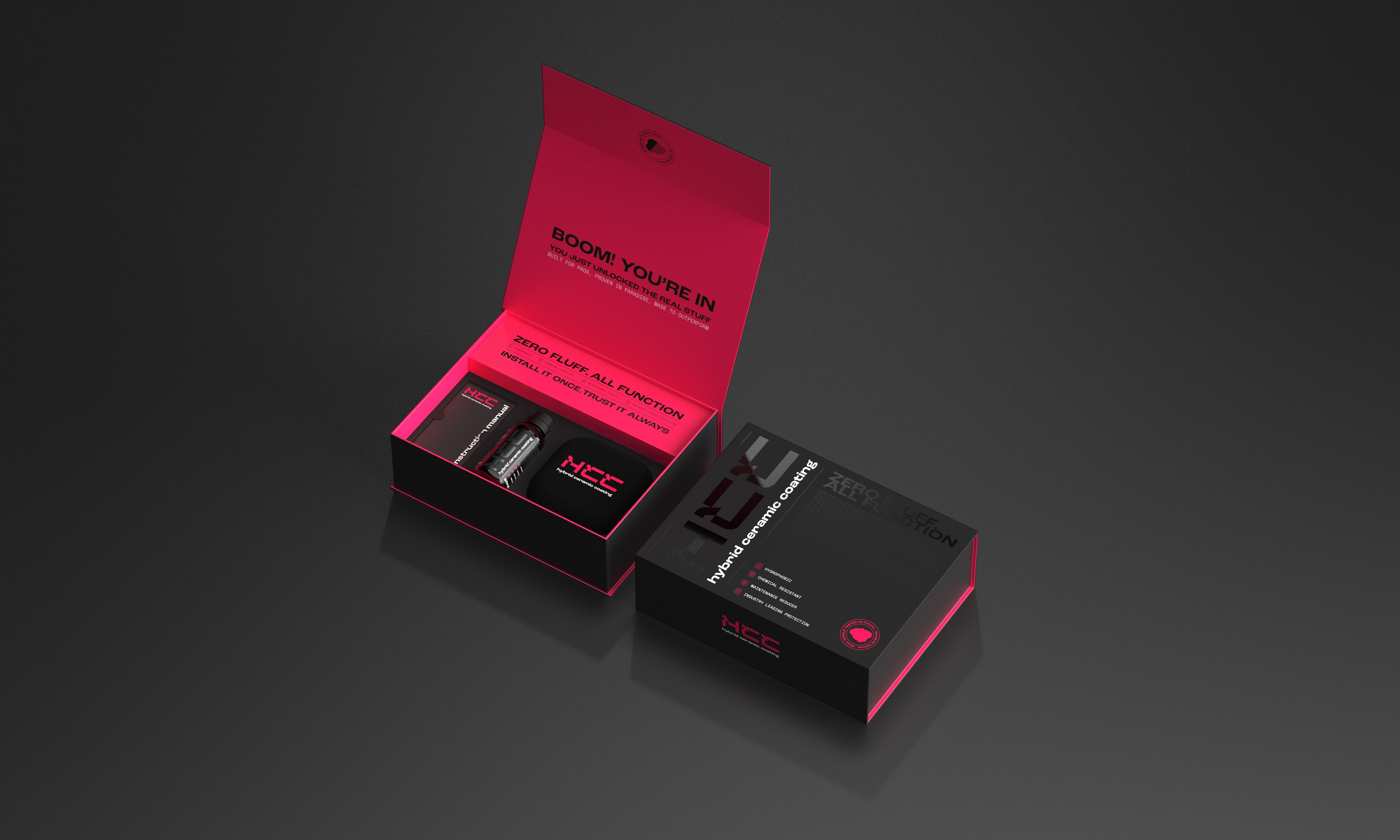 An open black and pink box displays a small black vial of Undrdog Surface Products' HCC - Hybrid Ceramic Composite and a card. The exterior features bold white and pink branding, highlighting its professional-grade surface protection.