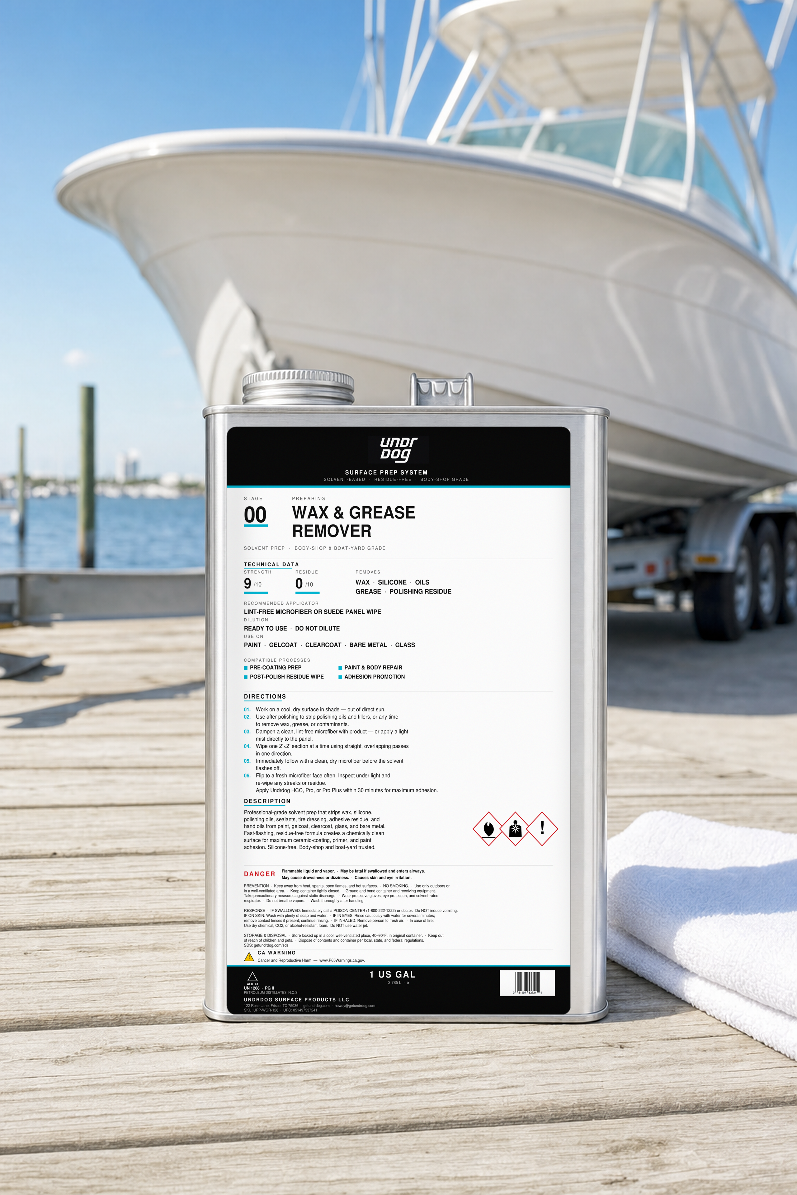 Undrdog Wax & Grease Remover gallon on a marina dock in front of a boat hull